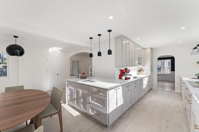 kitchen featuring black electric cooktop, decorative light fixtures, gray cabinetry, and sink