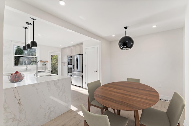 dining area with sink and light hardwood / wood-style flooring