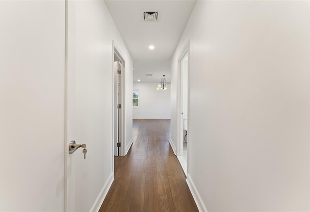 hallway featuring a chandelier and dark hardwood / wood-style floors