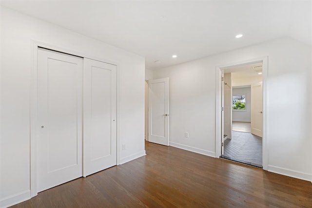 unfurnished bedroom featuring a closet and dark hardwood / wood-style floors