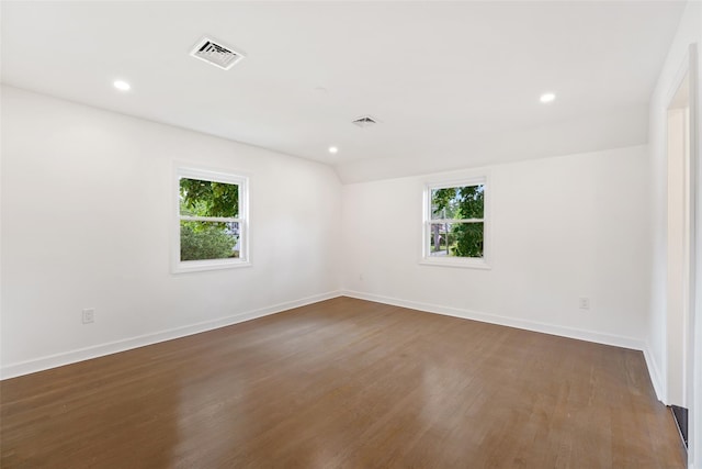 empty room with dark hardwood / wood-style floors and lofted ceiling