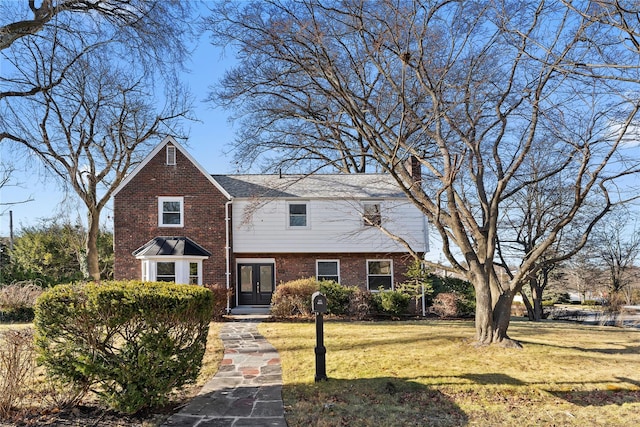 view of front of property featuring a front yard and french doors