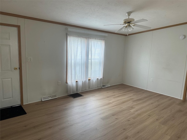 unfurnished room with ceiling fan, ornamental molding, a textured ceiling, and light hardwood / wood-style flooring