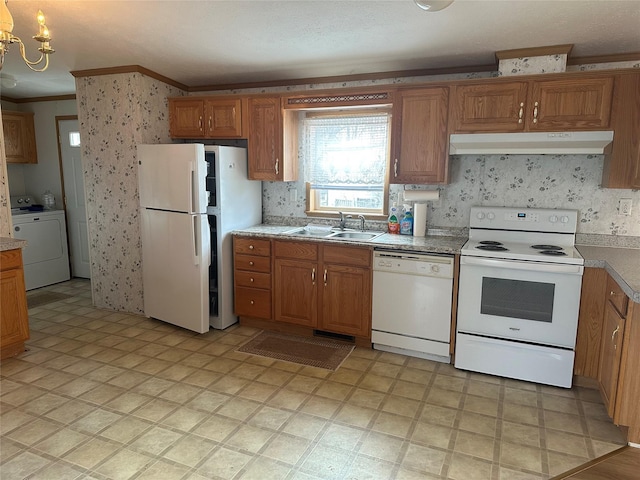 kitchen featuring white appliances, crown molding, sink, washer / dryer, and a chandelier