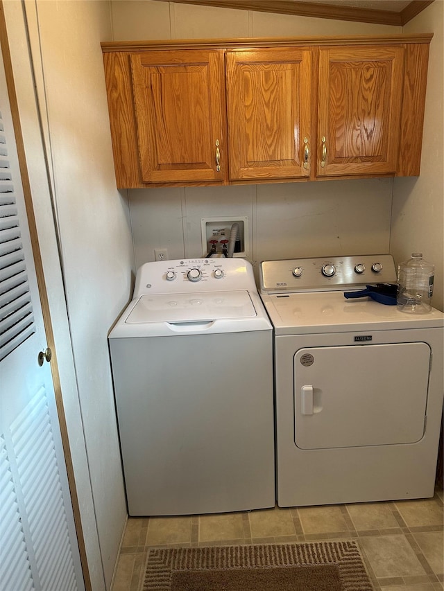 laundry room with washing machine and clothes dryer and cabinets