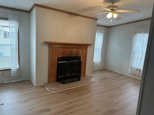 unfurnished living room featuring ceiling fan, light hardwood / wood-style floors, a healthy amount of sunlight, and ornamental molding