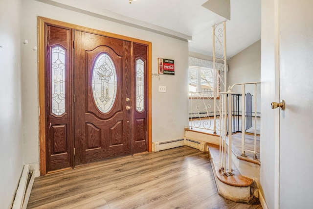 entrance foyer featuring wood-type flooring, vaulted ceiling, and a baseboard heating unit