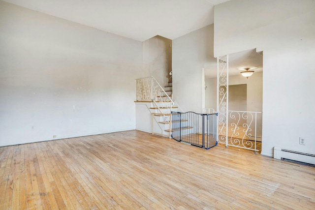 unfurnished room featuring a baseboard radiator and light wood-type flooring