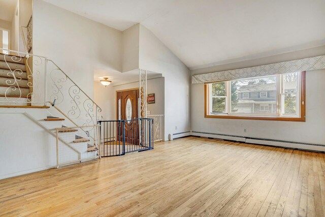 unfurnished living room with vaulted ceiling, wood-type flooring, and a baseboard radiator