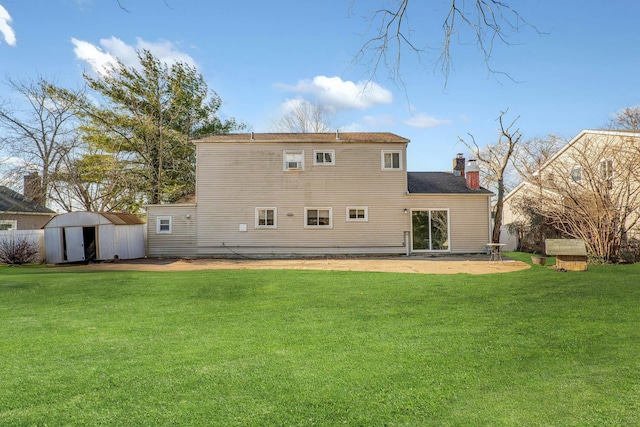 rear view of house with a lawn, a patio, and a shed