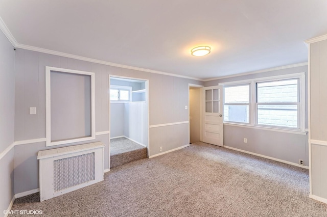 unfurnished bedroom featuring radiator, crown molding, and carpet