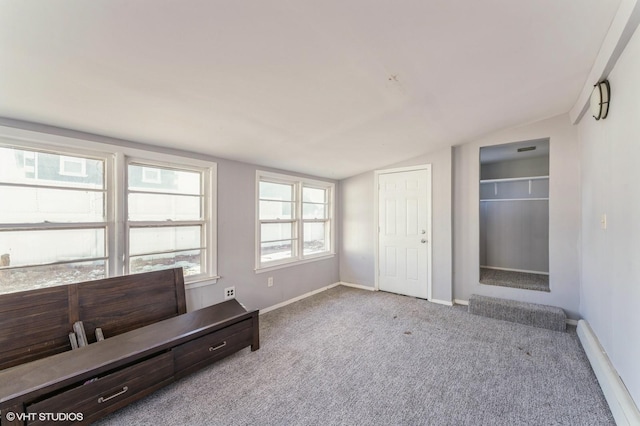 unfurnished room featuring light colored carpet, vaulted ceiling, and plenty of natural light