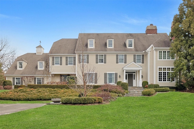 view of front of property featuring a chimney and a front lawn