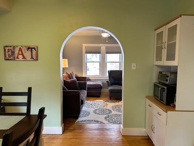 living room with ceiling fan and light wood-type flooring