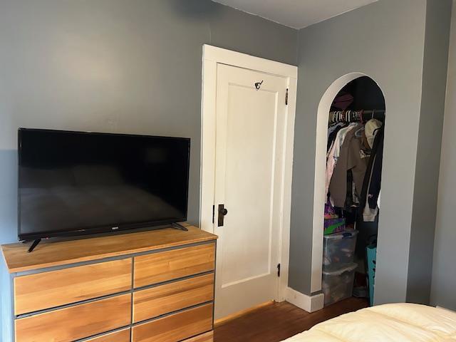 bedroom with dark hardwood / wood-style flooring and a closet