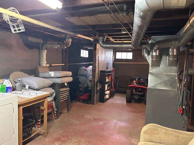 basement featuring washer / dryer and heating unit