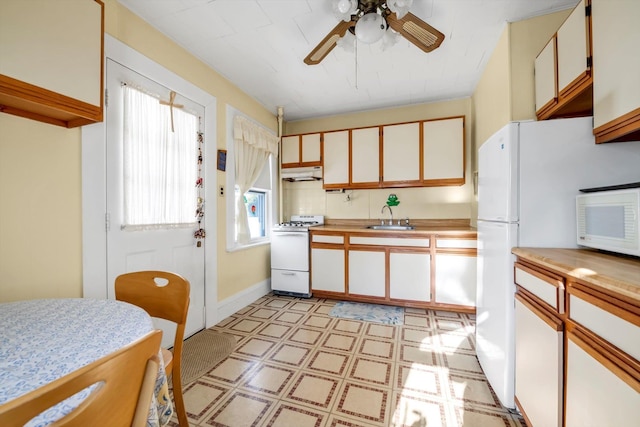 kitchen with white appliances, white cabinetry, a wealth of natural light, and sink