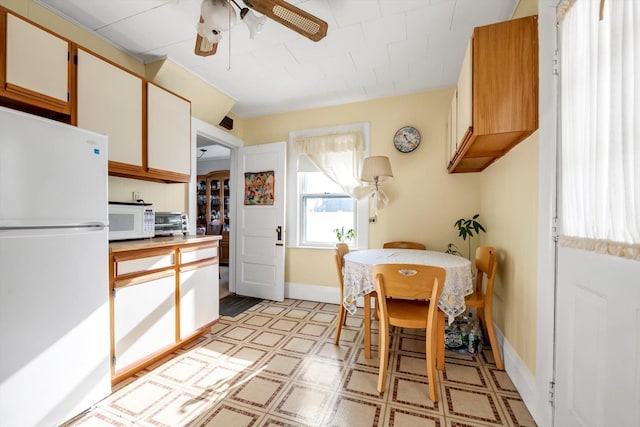 kitchen featuring white appliances, white cabinetry, and ceiling fan