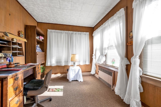 home office featuring radiator, wooden walls, and light colored carpet