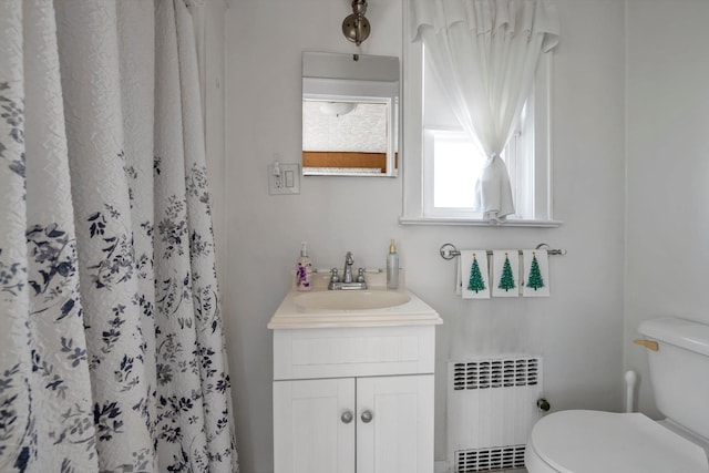 bathroom featuring a shower with curtain, vanity, toilet, and radiator