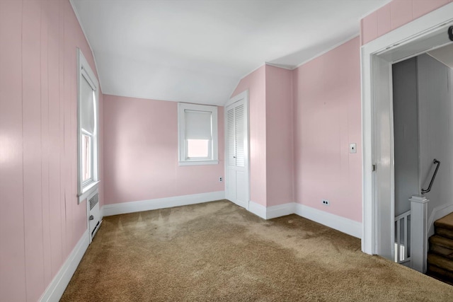 carpeted empty room with lofted ceiling