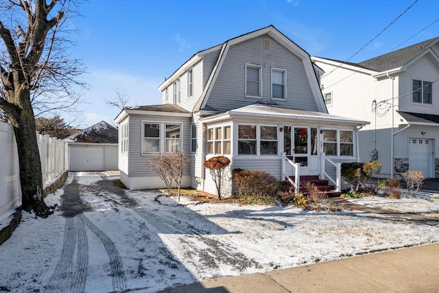 view of front of home featuring a garage, an outdoor structure, and a sunroom