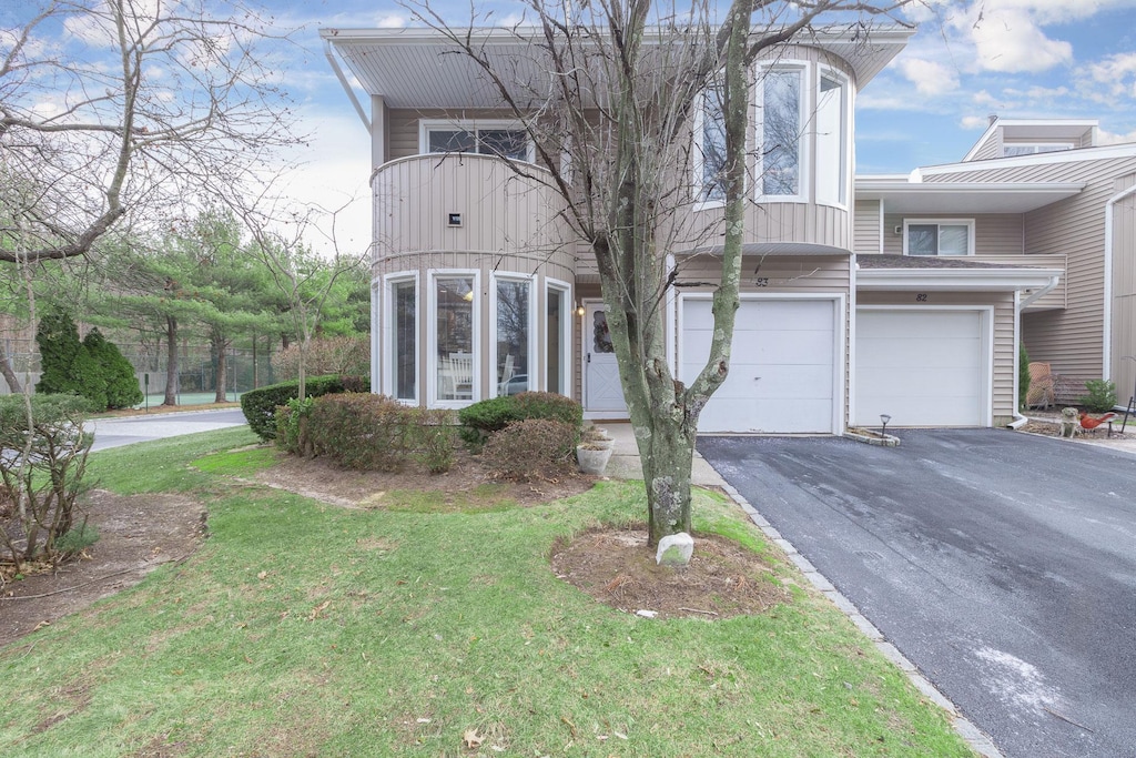 view of front of home with a front lawn and a garage