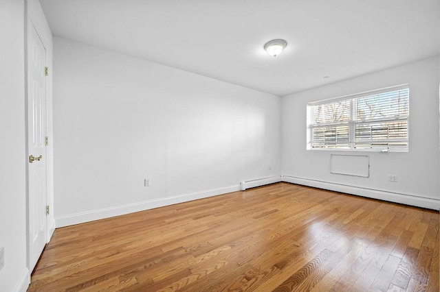 unfurnished room featuring light wood-type flooring and a baseboard radiator