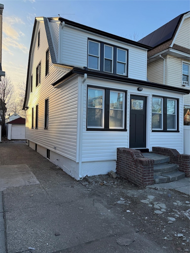 view of front of home with a garage and an outbuilding