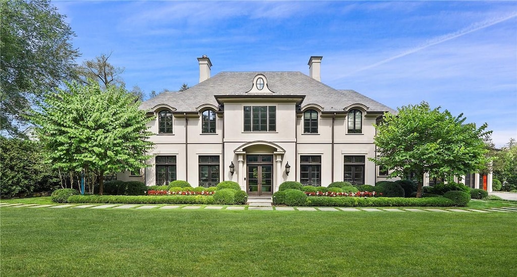 french country style house featuring french doors and a front lawn