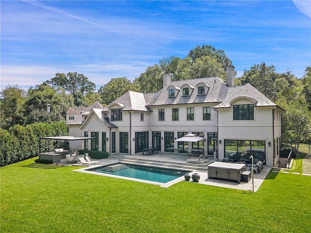 rear view of house with outdoor lounge area, a yard, and a patio