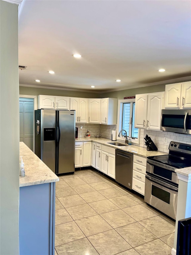 kitchen featuring appliances with stainless steel finishes, light stone counters, ornamental molding, sink, and white cabinets