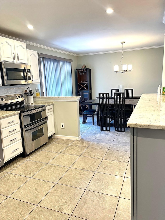 kitchen featuring white cabinets, crown molding, hanging light fixtures, stainless steel appliances, and a chandelier