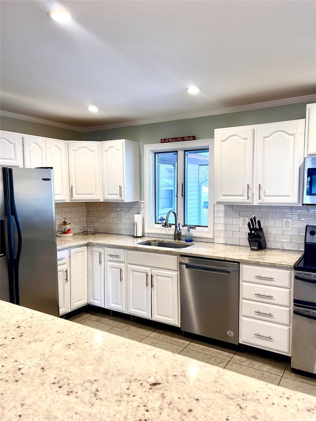 kitchen with white cabinets, light tile patterned flooring, sink, and stainless steel appliances