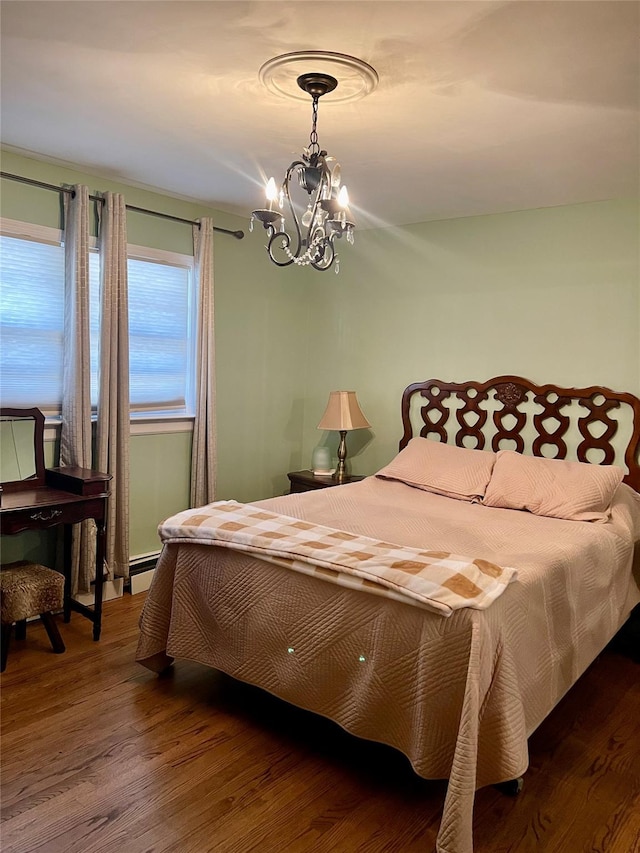 bedroom with hardwood / wood-style floors, a notable chandelier, and a baseboard heating unit