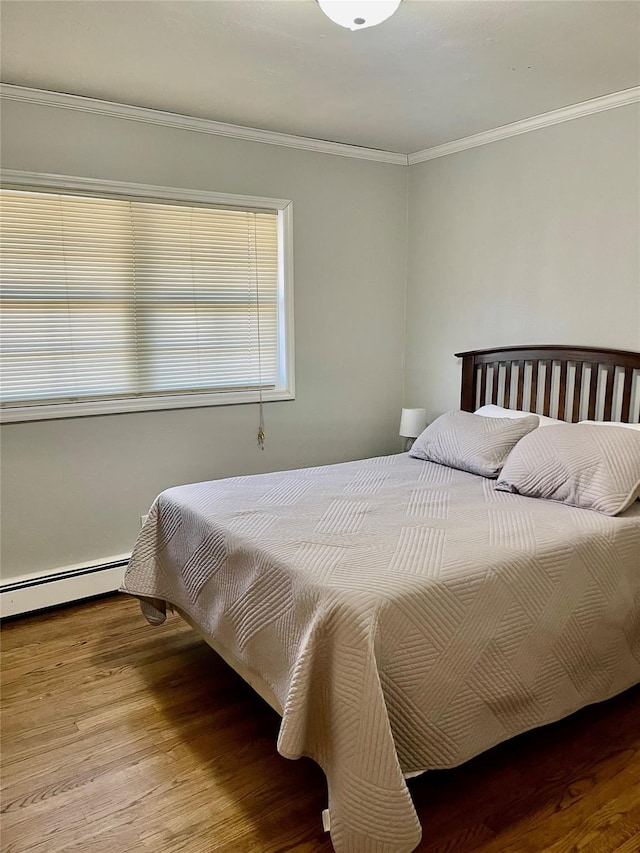 bedroom featuring wood-type flooring, baseboard heating, and ornamental molding