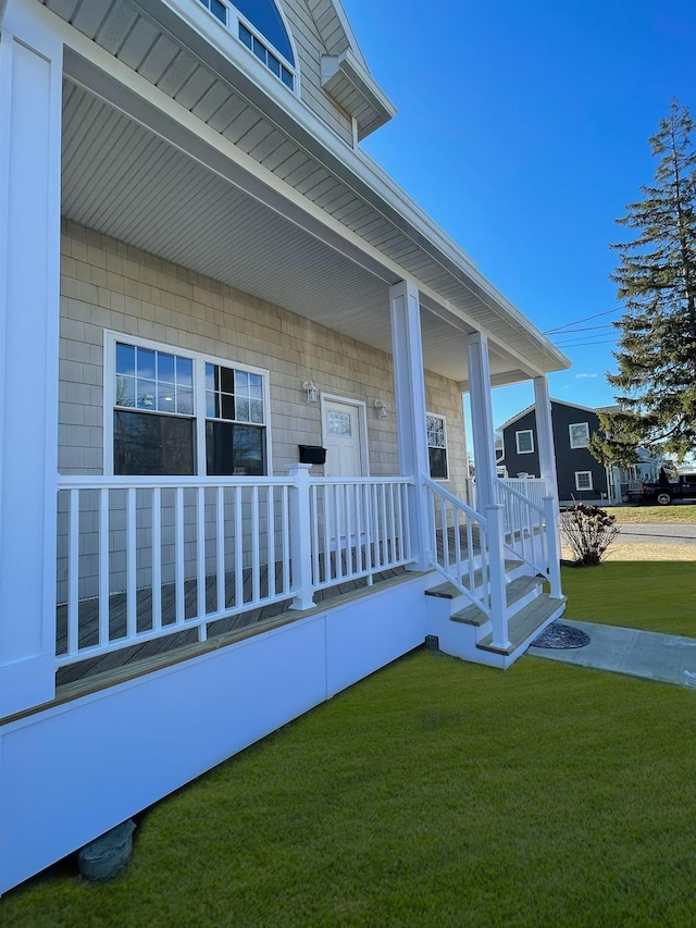 property entrance featuring a yard and a porch