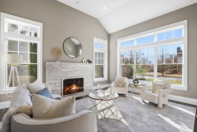 living room with lofted ceiling, a fireplace, and plenty of natural light