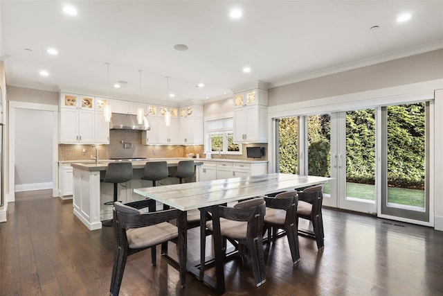 dining space featuring sink, dark hardwood / wood-style flooring, and crown molding