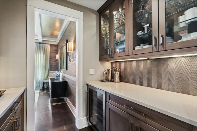 bar featuring dark hardwood / wood-style floors, dark brown cabinetry, and wine cooler