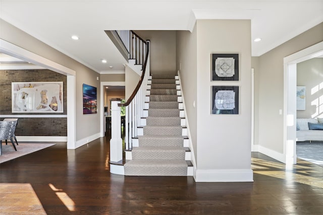 stairs featuring ornamental molding and hardwood / wood-style floors