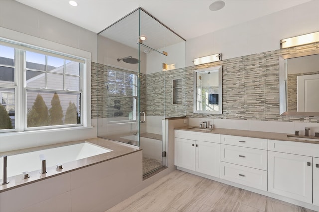 bathroom featuring decorative backsplash, plus walk in shower, and vanity