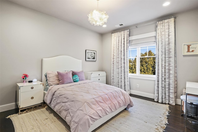 bedroom featuring a chandelier and hardwood / wood-style floors