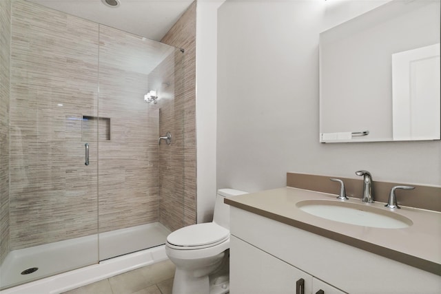 bathroom with vanity, tile patterned flooring, a shower with shower door, and toilet