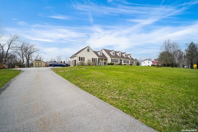 view of front of home with a front yard and a storage shed