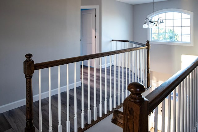 stairs featuring a chandelier and hardwood / wood-style flooring