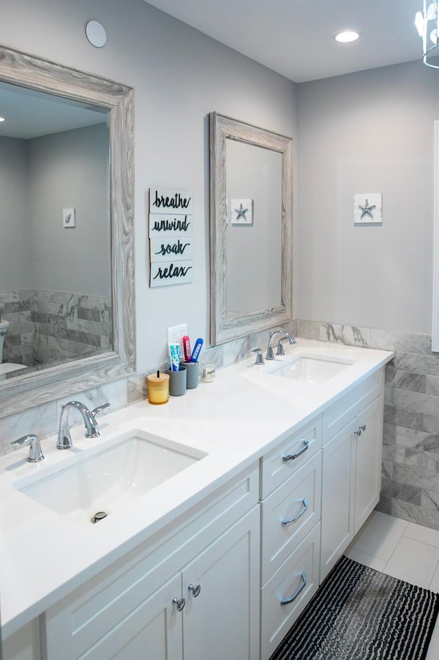 bathroom with tile patterned flooring, vanity, and tile walls