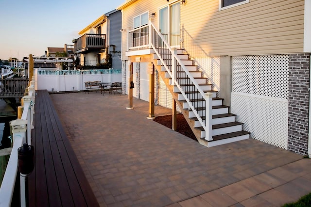 deck at dusk featuring a patio area