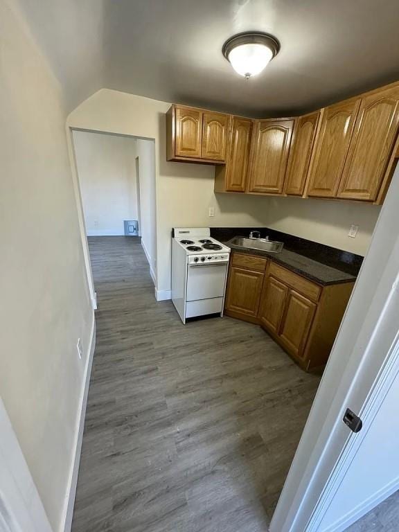 kitchen featuring white range oven, light wood-type flooring, and sink