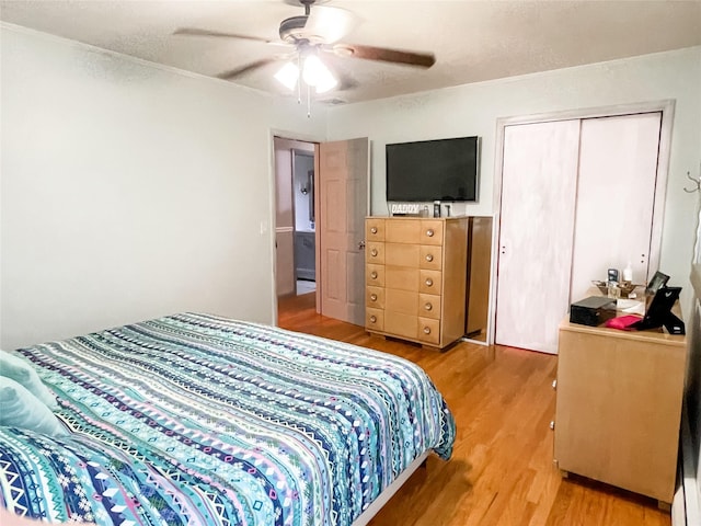 bedroom with a closet, hardwood / wood-style flooring, and ceiling fan